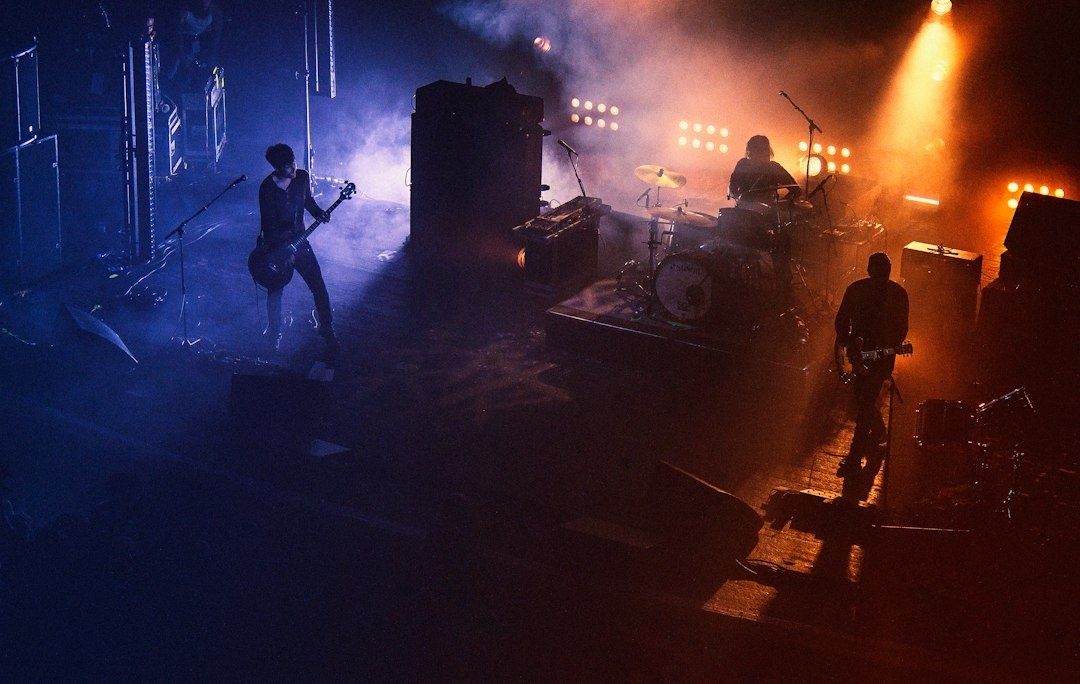 Rockband mit Gitarren und Schlagzeug in kontrastreicher Bühnenbeleuchtung